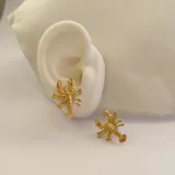 Par de aros con forma de langosta, de acero quirúrgico hipoalergénico con baño de oro de 18K.