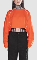 Remera corta naranja con mangas cortas abullonadas y ribete blanco en cuello, mangas y laterales.