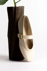 Ballerinas negras de cuero con tira sobre el empeine y hebilla dorada.