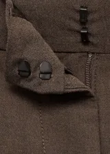 Pantalón de vestir marrón con pinzas, tiro medio, corte recto y bolsillos laterales. Incluye trabillas para cinturón, cierre oculto con botón, gancho y cremallera, botón decorativo y bolsillo de ribete en la parte posterior.