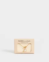 Pulsera dorada de acero inoxidable con dije de corazón de nácar y cadena extensible.