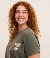 Blusa verde militar de algodón con cuello redondo y mangas cortas con dobladillo. Presenta un pequeño bordado de flores en el frente.