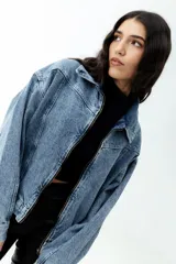 Campera de jean celeste con lavado ácido, corte cropped y cierre frontal con cremallera metálica.