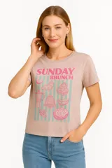 Remera celeste de manga corta y cuello redondo, con estampado de sardinas sobre fondo a cuadros rojos y blancos. Incluye texto con los nombres de las ciudades de Cagliari y Sardina.