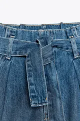 Bermuda de jean celeste, tiro alto, corte paper bag, con trabillas y cinturón lazada. Tiene bolsillos laterales y traseros.