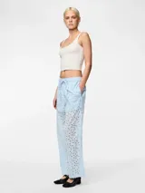 Pantalón celeste con broderie anglaise con cortes ovalados, cintura media y corte recto.