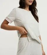 Conjunto de pijama gris claro melange, compuesto por una blusa de manga corta con botones y un pantalón capri con cintura elástica. Ambas prendas tienen detalles de encaje rosa.