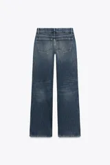 Pantalón de jean celeste claro, de tiro bajo, corte wide leg y largo hasta el tobillo. Tiene cinco bolsillos, cierre frontal con cremallera y botón metálico.