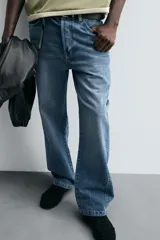 Pantalón de jean azul de tiro medio, corte flare, con cinco bolsillos y cierre frontal con cremallera y botón.