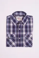 Camisa de manga corta con estampado a cuadros en tonos azul, rojo y blanco. Cierre con botones y tela ligera.