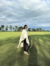 Zapatillas bajas con estampado animal print de vaca en blanco y negro, con cordones marrones y suela color caramelo.