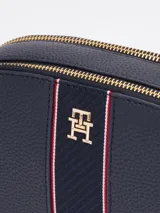 Bandolera ovalada azul marino con correa ajustable, cierre superior con cremallera y logo de la marca en el centro.