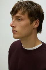 Buzo de tejido de mezcla de algodón de peso medio con interior cepillado suave. Modelo con cuello redondo ribeteado, hombros caídos y remate acanalado ancho en puños y bajo. Corte holgado.