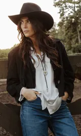 Chaqueta de cuero ovino italiano color beige, con cuello camisero, cierre con botones, dos bolsillos plaqué, corte recto relajado y largo a la cintura. Forro interior de algodón.