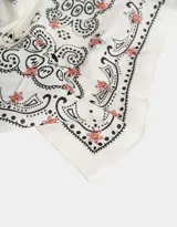 Pañuelo de algodón color crema con estampado de cachemira en negro y detalles florales en rosa.