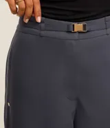 Pantalón pantalona de sastrería color gris azulado, de corte amplio y sin estampa. Tiene elástico en la espalda, cinturón en el mismo tejido y hebilla metalizada.