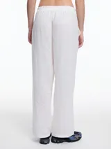 Pantalón negro de lino con elástico en la cintura y calce relajado. Incluye bolsillos laterales y un bolsillo invertido. Detalles de bordado tipo pespunte en color gris recorren la pierna y el bajo.