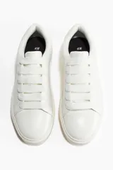 Championes blancos de cuero con cordones y suela gruesa.
