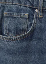 Pantalón de jean azul oscuro, de tiro alto, corte flare y cinco bolsillos.