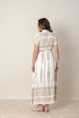 Vestido largo blanco de algodón con bordados dorados, corte recto, cintura elastizada, cuello en V y mangas cortas.
