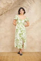 Vestido midi blanco con estampado floral en tonos verdes, escote en V, mangas cortas abullonadas y corte evasé.