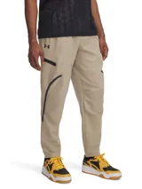 Pantalón de jogging Under Armour para hombre, color beige, con corte ajustado, cintura elástica, bolsillos laterales con cierre y bolsillos cargo con solapa. Logo de la marca en la cadera izquierda. Confeccionado en tejido técnico resistente al agua y elástico.