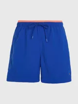 Bañador azul eléctrico de largo medio, con cintura elástica ajustable con cordón, ribete naranja en la cintura y logo de Tommy Hilfiger bordado en la parte trasera.