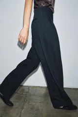 Pantalón de vestir azul marino con raya diplomática, tiro medio, corte wide leg, pinzas delanteras, bolsillos traseros y cierre frontal con cremallera y doble botón. Colección Zara Woman.