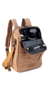Mochila matera confeccionada en tela impermeable color beige, diseñada con dos compartimientos independientes para el kit de mate y objetos personales. Cuenta con bolsillos internos, asas de mochila acolchadas, asa de mano superior y una correa ajustable extraíble para llevar al hombro.
