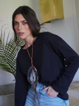 Remera negra de manga larga con cuello redondo. Jeans de tiro alto color celeste con cinturón con hebilla dorada. 