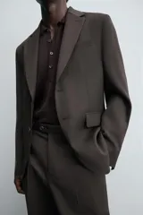 Blazer regular fit color negro confeccionada en tejido de lana. Cuello con solapas de muesca y manga larga acabada en puño con detalle de botones. Bolsillos de vivo en pecho y de solapa en cadera. Detalle de bolsillo interior. Bajo con aberturas en espalda. Cierre frontal de botonadura.