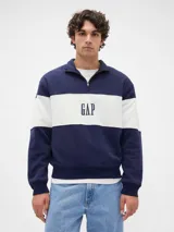 Buzo de algodón color azul marino con diseño de bloques de color, presentando una franja horizontal blanca en el pecho con el logo "GAP" estampado en azul oscuro. Tiene cuello alto con cierre parcial (medio cierre) y puños y cintura acanalados.