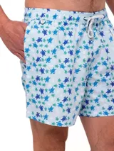 Short de baño celeste con estampado de ballenas en azul y gris. Tiene cintura elástica con cordón ajustable y bolsillos laterales.
