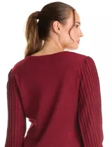 Buzo de tejido lurex marca Nanette en color bordó, con cuello a la base y mangas largas de diseño plisado. Los puños cuentan con apliques de botones decorativos.