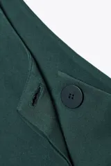 Top verde esmeralda de escote asimétrico con manga sisa y cinturón con hebilla forrada.