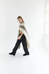 Ruana artesanal color beige con rayas horizontales rojas y amarillas, y flecos en el borde inferior.