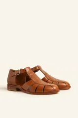 Sandalias de cuero color marrón claro, con diseño de tiras entrecruzadas y hebilla lateral.
