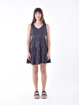 Vestido corto gris oscuro con escote en V, sin mangas, corte imperio y falda escalonada con botones decorativos.