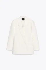 Blazer blanco de corte oversize, con cuello solapa, manga larga con hombreras, bolsillos de doble vivo en el delantero, aberturas en la espalda y cierre cruzado con botones.