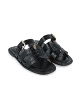 Sandalia chata de cuero negro con textura croco, hebilla metálica de ajuste en el empeine y suela de TR.