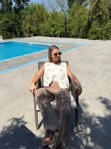 Chaleco sin mangas color beige claro, con bordados florales en relieve y abertura frontal.