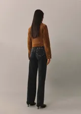Pantalón de jean negro de corte recto con tachas plateadas en los laterales.