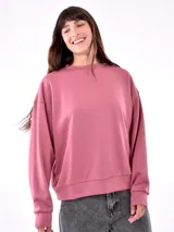 Buzo deportivo color rosa viejo, de corte holgado y mangas largas.