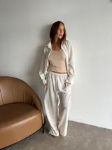 Camisa de manga larga color crudo o blanco roto, de tejido ligero con textura visible, corte holgado y cuello camisero.