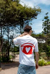Remera blanca de corte holgado con estampa frontal con la frase "Tu intuición siempre sabe" en color rojo.