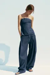 Pantalón de denim azul con pinzas delanteras, tiro medio, cintura con trabillas, bolsillos laterales y traseros.