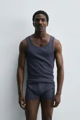 Conjunto de pijama color gris compuesto por una camiseta sin mangas de corte ajustado y un bóxer corto con cintura elástica y botones.