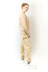 Pantalón de jogging color beige, con cintura elástica ajustable con cordón, bolsillos laterales y un bolsillo tipo cargo con solapa en la pierna derecha.