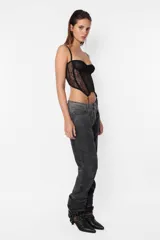 Corset negro de encaje con recortes y ballenas. Tazas forradas con aro metálico interno media copa. Terminaciones con elástico partido y breteles elásticos regulables. Acceso por espalda mediante ganchos lenceros. Detalle de terminación con portaligas.