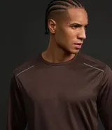 Remera deportiva azul con cuello redondo y mangas largas. Estampa rayada discreta y detalles reflectantes.